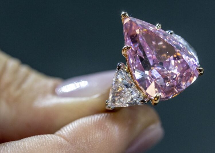 Vivid pink diamond could go for $35 mln at Christie's auction 1 - Egyptian Gazette A model holds a 18,18 carat pink diamond called "Fortune Pink" that could fetch 30 million US dollars during a preview at Christie’s before the auction sale in Geneva, Switzerland.