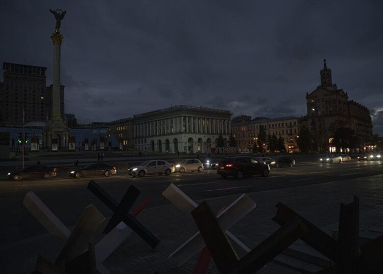 Cars pass in Independence Square at twilight in Kyiv, Ukraine, on Monday, October 31, 2022.