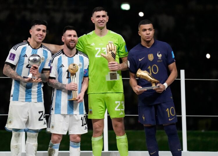 Argentina's Enzo Fernandez, Lionel Messi, goalkeeper Emiliano Martinez, and France's Kylian Mbappe, from left to right, pose with their individual awards at the end of the World Cup final between Argentina and France at the Lusail Stadium in Lusail, Qatar, Dec. 18, 2022.
