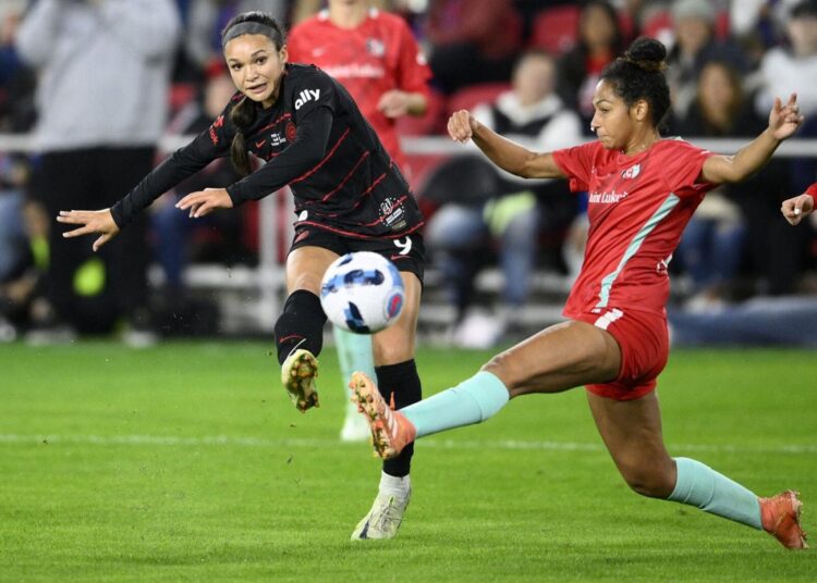 Portland Thorns FC forward Sophia Smith (L) kicks the ball against Kansas City Current defender Addisyn Merrick during the NWSL championship match on Oct. 29, 2022, in Washington.
