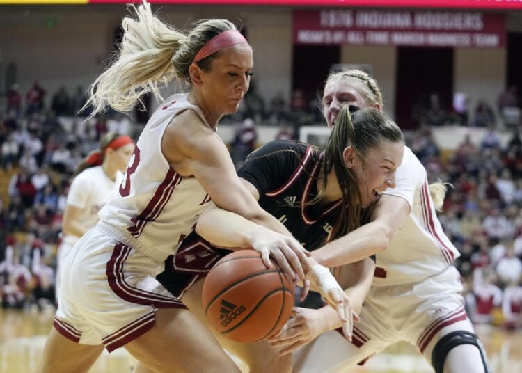 Nebraska's Isabelle Bourne (C) is trapped by Indiana's Sydney Parrish (L) and Lexus Bargesser during their NCAA college basketball game, in Bloomington.