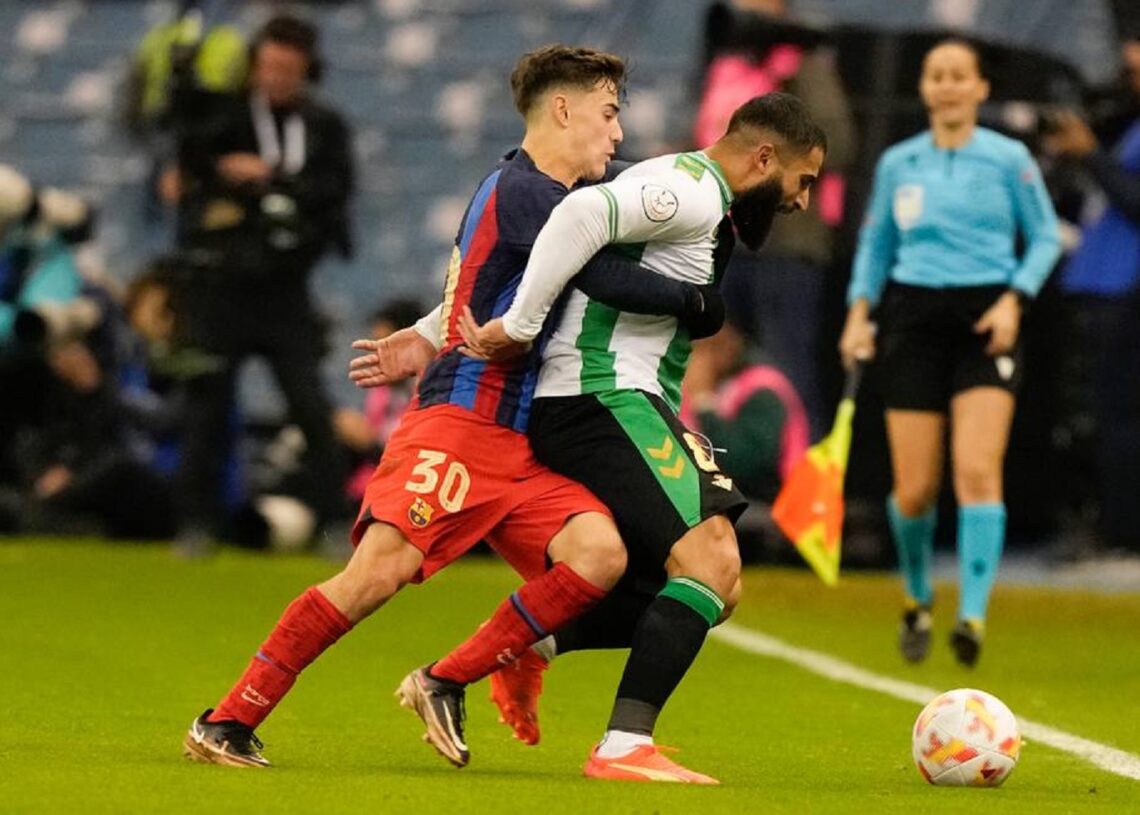 Barcelona's Gavi (L) and Betis' Nabil Fekir fight for the ball during Spanish Super Cup semi-final in Riyadh, Saudi Arabia.