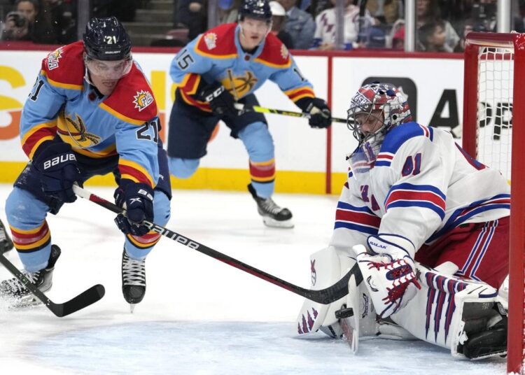 New York Rangers goaltender Jaroslav Halak (R) stops a shot on the goal by Florida Panthers Nick Cousins (L) during their NHL game in Sunrise, Florida.