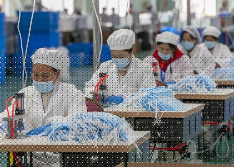 Chinese factories eye gradual recovery after Lunar break 1 - Egyptian Gazette A file photo shows workers make face masks at a Chinese plant in Shanghai on April 8, 2022.