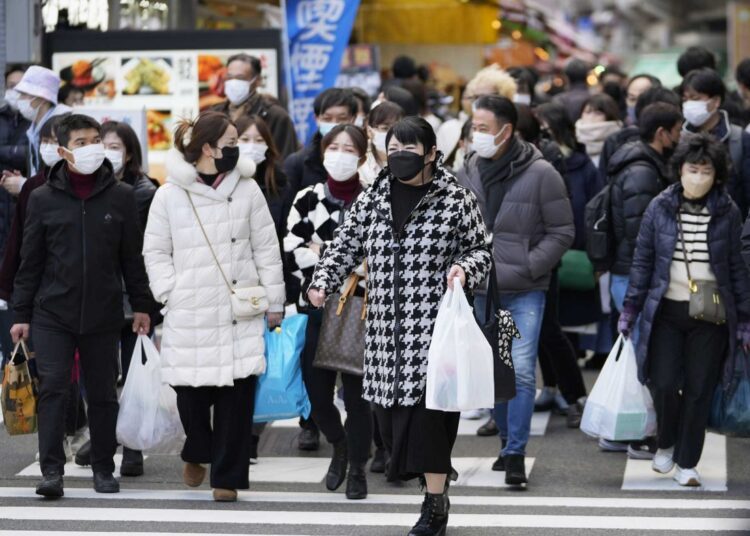 Japan reports inflation hit 4%, 41-year high in December 1 - Egyptian Gazette People with shopping bags walk across a traffic intersection towards a train station near a shopping street in the Ueno district in Tokyo on Dec. 30, 2022.