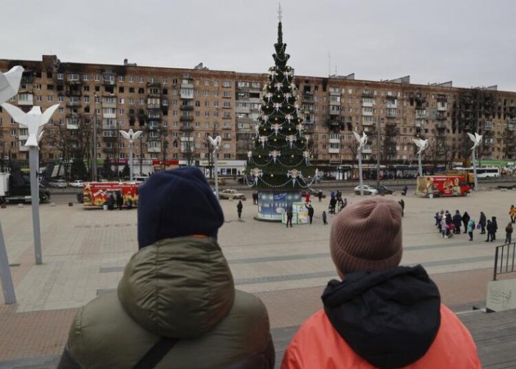 Kremlin-ordered truce is uncertain amid suspicion of motives 11 - Egyptian Gazette Local citizens walk near a Christmas tree decorated for Orthodox Christmas and the New Year festivities in Mariupol, in Russian-controlled Donetsk region, eastern Ukraine on Jan. 5, 2023.