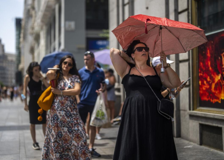 A woman holds an umbrella to shelter from the sun during a hot sunny day in Madrid, Spain, July 18, 2022.