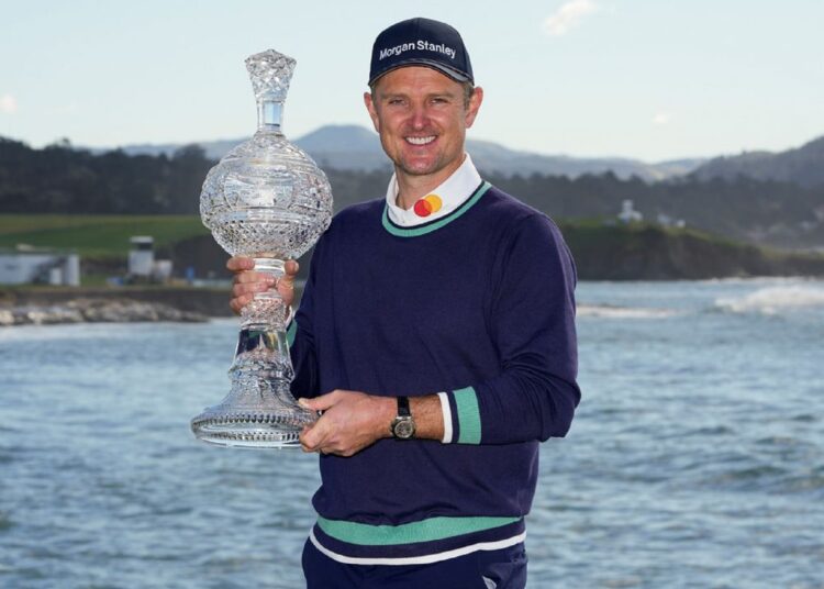 Justin Rose poses with the trophy after winning the Pebble Beach Pro-Am golf tournament.