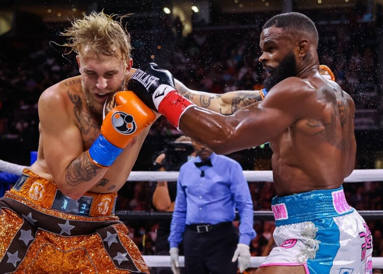 Jake Paul (L) delivers a punch to Tyron Woodley during their boxing match on August 29, 2021.