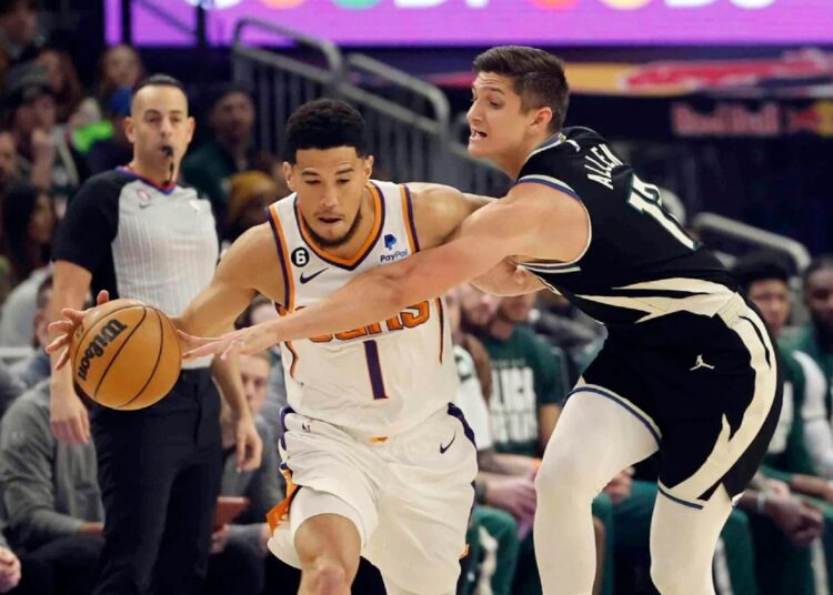 Milwaukee Bucks Grayson Allen (R) reaches in on Phoenix Suns Devin Booker during an NBA game in Milwaukee.