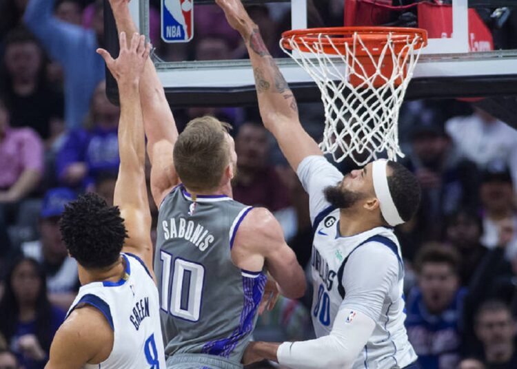 Sacramento Kings Domantas Sabonis (10) shoots over Dallas Mavericks JaVale McGee (R) during an NBA game in Sacramento, California.