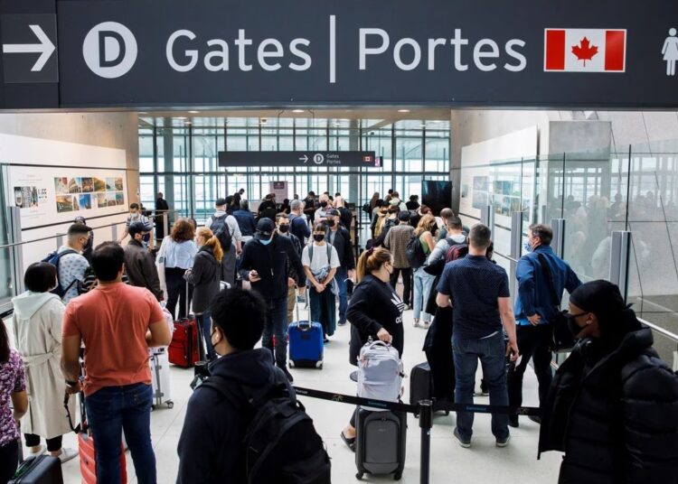 Travellers crowd the security queue in the departures lounge at the start of the Victoria Day holiday at Toronto Pearson International Airport in Mississauga, Ontario, Canada, May 20, 2022.