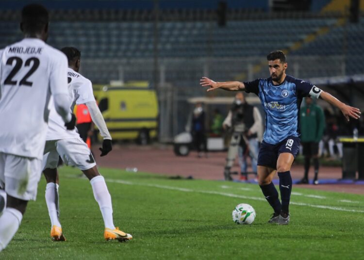 Pyramids FC playmaker Abdullah el-Said (R) controls the ball against AS Kara defenders during the match at Group C.