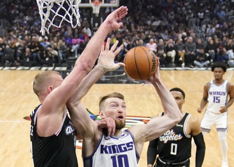 Sacramento Kings Domantas Sabonis (C) shoots as Los Angeles Clippers Mason Plumlee (L) and guard Russell Westbrook defend during an NBA game in Los Angeles.