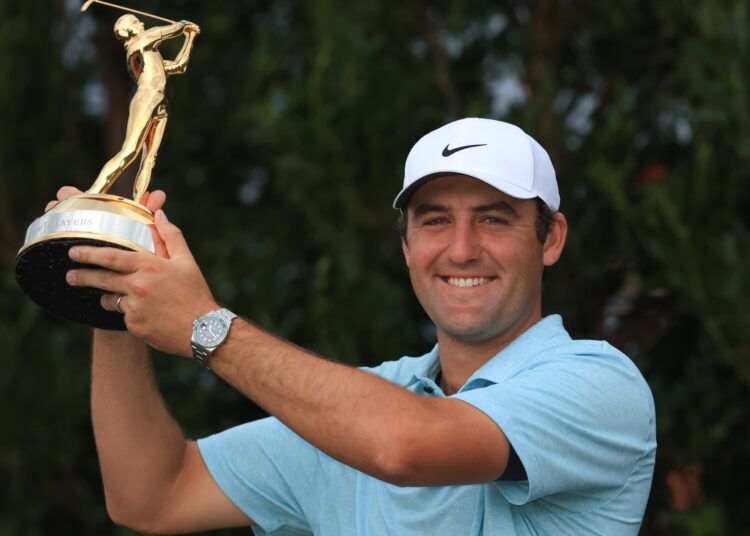 Scottie Scheffler poses with the trophy of the Players Championship.