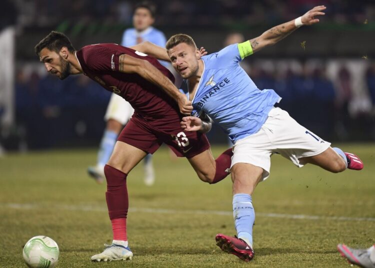CFR's Denis Kolinger (L) challenges for the ball with Lazio's Ciro Immobile during their Europa Conference League playoff second-leg match in Cluj, Romania.