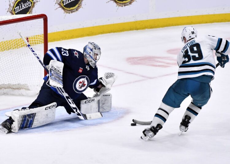 San Jose Sharks' Logan Couture (R) scores on Winnipeg Jets goaltender David Rittich during an NHL hockey game, in Winnipeg, Manitoba.