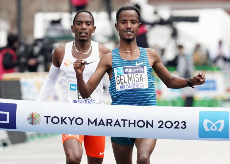 Deso Gelmisa of Ethiopia (R) runs to finish and win the men's race of Tokyo Marathon, followed by his compatriot Mohamed Esa.