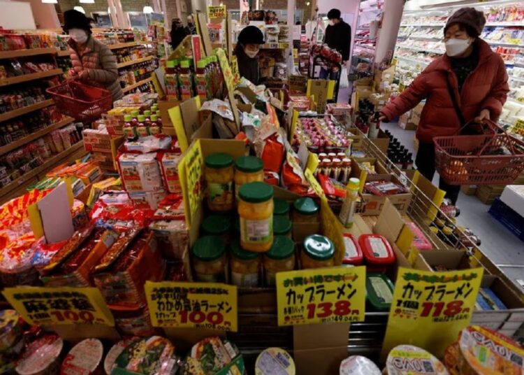 Shoppers check food items at a supermarket in Tokyo, Japan on January 20, 2023.