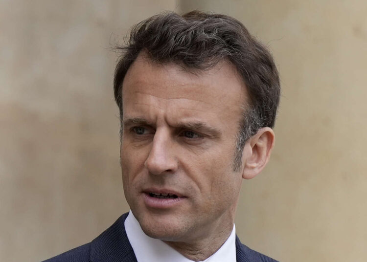 French President Emmanuel Macron looks on as he talks with Senegalese war veterans Friday, April 14, 2023 at the Elysee Palace in Paris. Some of the last survivors in France from a colonial-era infantry corps that recruited tens of thousands of African soldiers to fight in French wars around the world will be able to live out their final days with family members back in Africa after a French government U-turn earlier this year on their pension rights. (AP Photo/Lewis Joly, Pool)