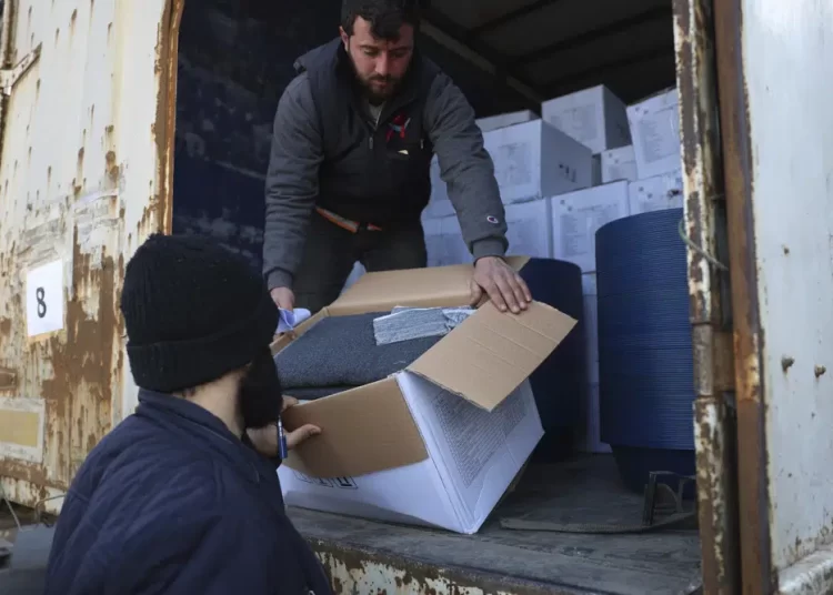 FILE - Border customs officials inspect a truck loaded with United Nations humanitarian aid for Syria following a devastating earthquake at the Bab al-Hawa border crossing with Turkey, in Syria's Idlib province, on Feb. 10, 2023. A U.N. commission said Monday, March 13, that the international community and the Syrian government did not act quickly last month to help people in need in the rebel-held northwest of Syria in the first critical days after the earthquake hit