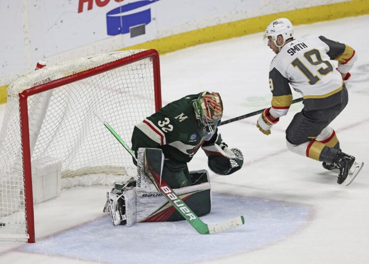Vegas Golden Knights Reilly Smith (R) scores the winning goal in a shootout against Minnesota Wild goaltender Filip Gustavsson during an NHL hockey game.