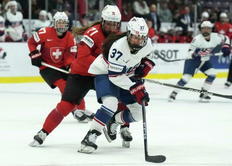 United States forward Abbey Murphy (R) gets chased down by Switzerland forward Lena Marie Lutz during the women's world hockey championships in Brampton, Ontario.