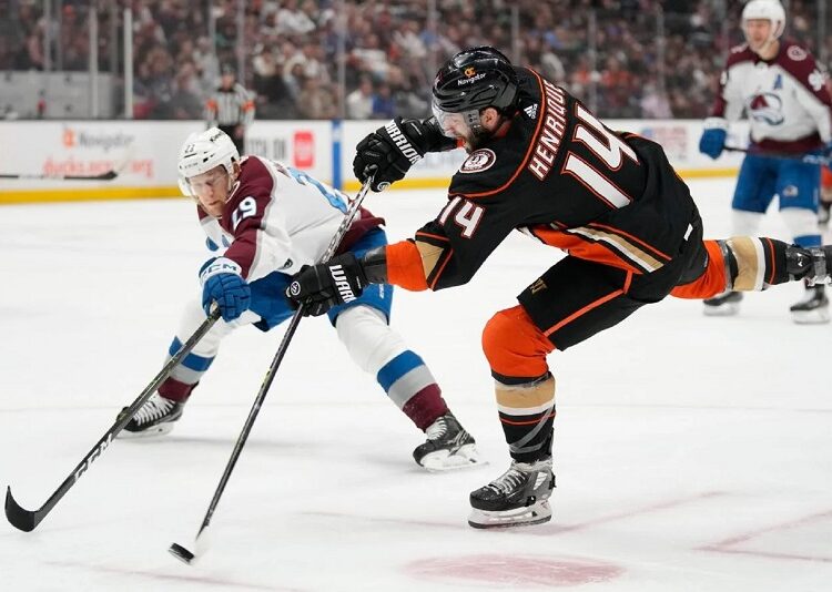 Anaheim Ducks Adam Henrique (R) shoots against Colorado Avalanche Nathan MacKinnon during an NHL hockey game in Anaheim.