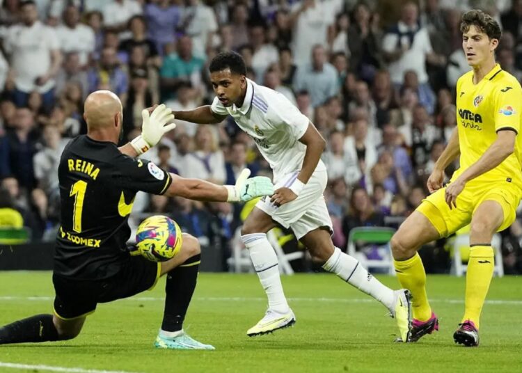 Real Madrid's Rodrygo (C) challenges Villarreal's goalkeeper Pepe Reina during their Spanish La Liga match in Madrid.