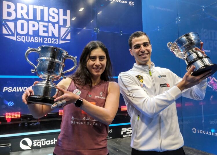 Egypt’s Nour el-Sherbini and Ali Farag pose with the British Open trophies.