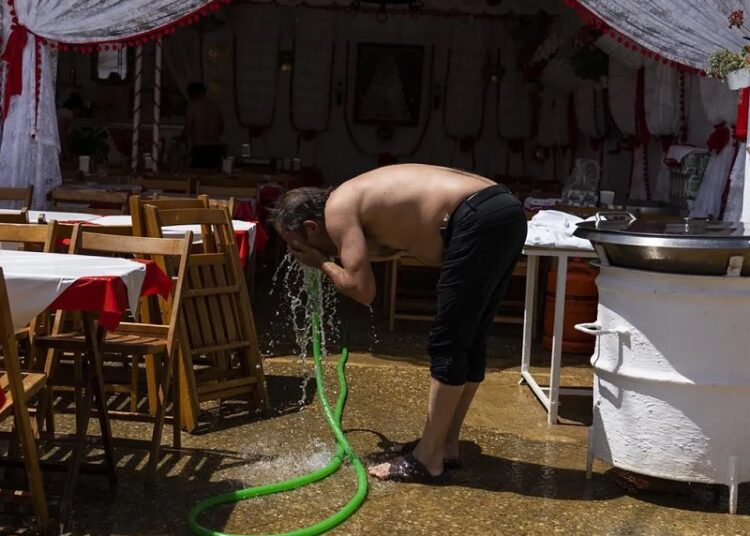 Spain announces exceptional drought measures worth $2.4B 1 - Egyptian Gazette FILE - A man refreshes himself with a water hose outside a 'caseta' (tent where food and drinks are served) in the annual traditional April Fair in Seville, Spain, on April 27, 2023.