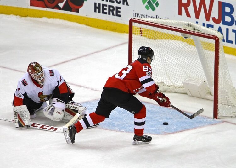 New Jersey Devils' Jesper Bratt (R) scores against the Carolina Hurricanes during their NHL Stanley Cup playoff series on May 11, 2023.
