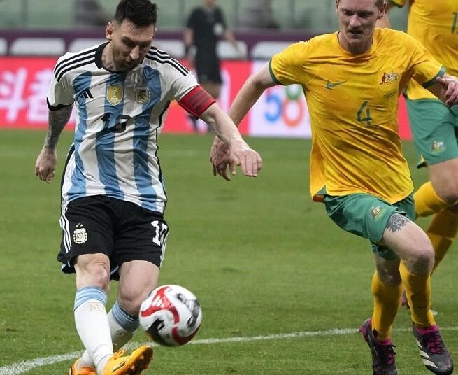 Argentina's Lionel Messi (L) shoots the ball at the goal past Australia's Kye Rowles during their friendly match in Beijing.