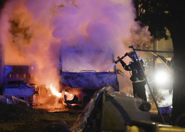 A firefighter works to extinguish a burning vehicle in Nantes, France, on Tuesday. Days of unrest have plagued the city after a police officer fatally shot a motorist at a checkpoint.