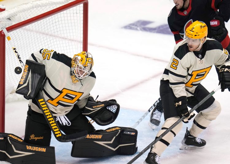Pittsburgh Penguins goaltender Tristan Jarry (L) blocks a shot with Chad Ruhwedel (R) during an NHL hockey game in Pittsburgh, on Jan. 20, 2023.
