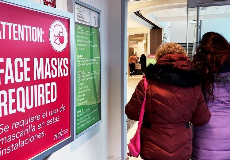 A sign announcing a face mask requirement is displayed at a hospital in Buffalo Grove, Ill., Friday, Jan. 13, 2023.