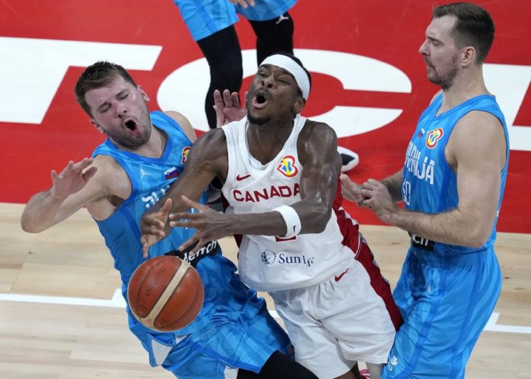 Canada's Shai Gilgeous-Alexander (C) collides with Slovenia's Luka Doncic (L) as Slovenia's Zoran Dragic defends during the World Cup quarter-final in Manila, Philippines.