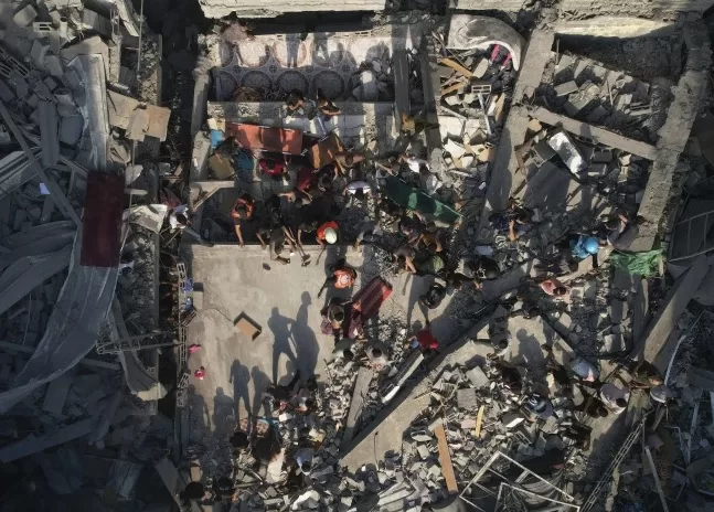 Hospitals in the Gaza Strip at a breaking point, warns WHO 1 - Egyptian Gazette Palestinians inspect the rubble of buildings hit by an Israeli airstrike at Al Shati Refugee Camp Thursday, Oct. 12, 2023.