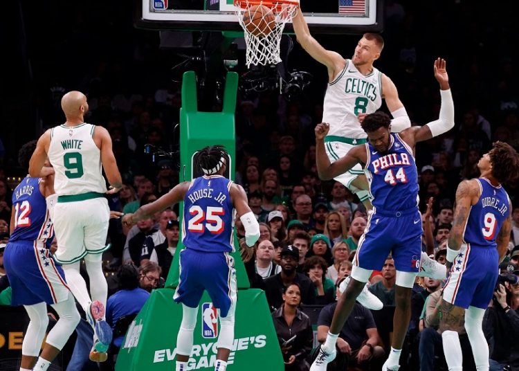 Boston Celtics center Kristaps Porzingis dunked over Paul Reed in the first of the preseason opener against the Philadelphia 76ers.