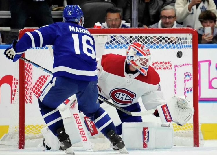 Toronto Maple Leafs' Mitchell Marner (L) scores on against Montreal Canadiens goaltender Jake Allen during the shootout in an NHL hockey game in Toronto.