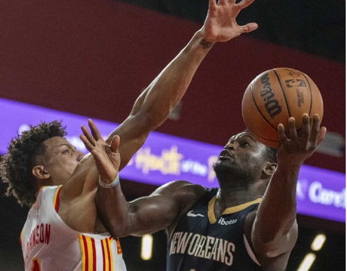 New Orleans Pelicans Zion Williamson (R) scores against Atlanta Hawks Jalen Johnson during the NBA basketball game in College Park, Ga.