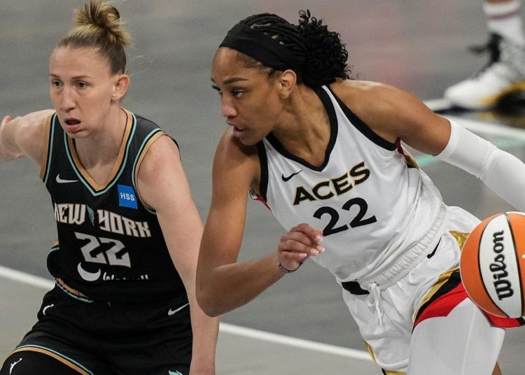 Las Vegas Aces' A'ja Wilson (R) drives past New York Liberty's Courtney Vandersloot during the WNBA basketball final playoff series.