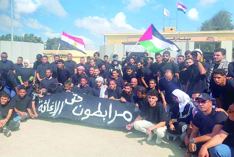Egyptian NGO volunteers protesting at Rafah Border Crossing, opposing Palestinian relocation to Sinai and calling for humanitarian aid to reach Gaza.