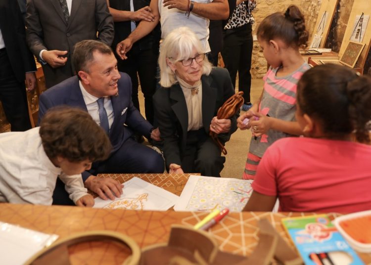 Minister Ahmed Issa and Ambassador Beth Jones talking to the children at the visitor centre.
