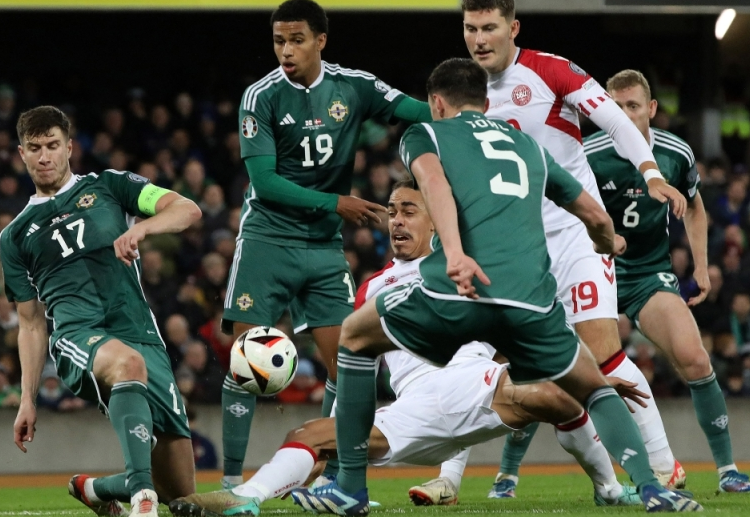 Northern Ireland's midfielder Paddy McNair (L) defends from Denmark's forward Yussuf Poulsen (C) during the UEFA Euro 2024 Group H qualifying match.