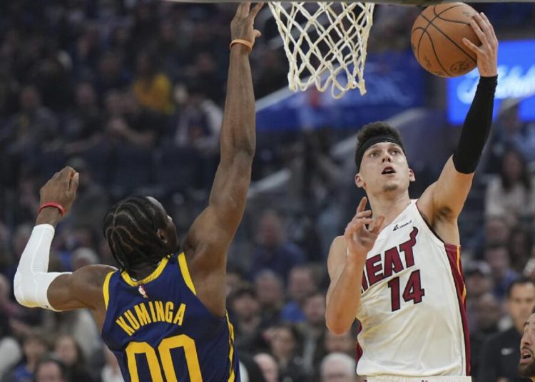 Miami Heat Tyler Herro (R) drives to the basket as Golden State Warriors Jonathan Kuminga defends during an NBA basketball game in San Francisco.