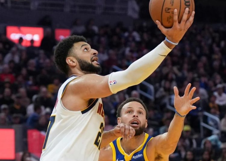 Denver Nuggets Jamal Murray (L) drives to the basket as Golden State Warriors Stephen Curry defends during the first half of an NBA basketball game in San Francisco.