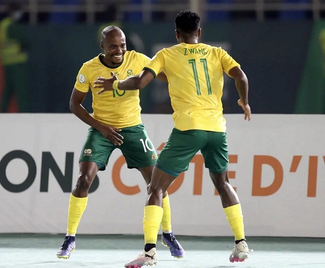 South Africa’s forward Percy Tau (L) celebrates with teammate Themba Zwane after scoring against Namibia.