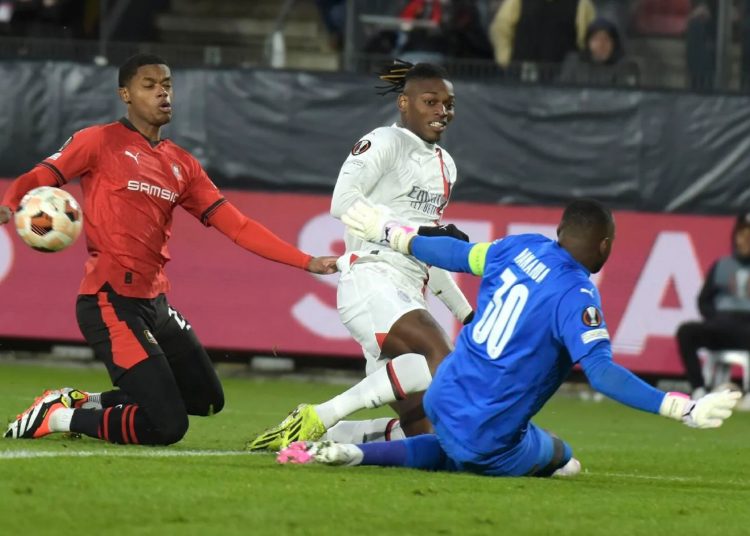 Rennes' goalkeeper Steve Mandanda (R) stops the ball by AC Milan's Rafael Leao (C) during the UEFA Europa League match in Rennes.