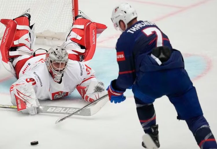 Poland's goalkeeper John Murrayv (L) makes a save in front of United States' Brady Tkachuk during the Ice Hockey World Championships in Ostrava, Czech Republic.
